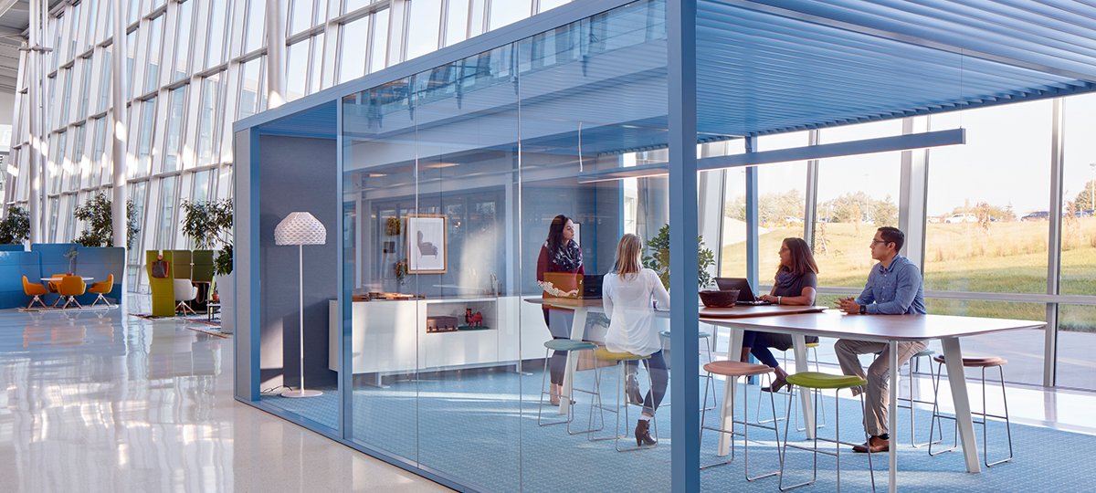 salle de rencontre dans un espace constitué d'une pergola en verre et métal de couleur bleu