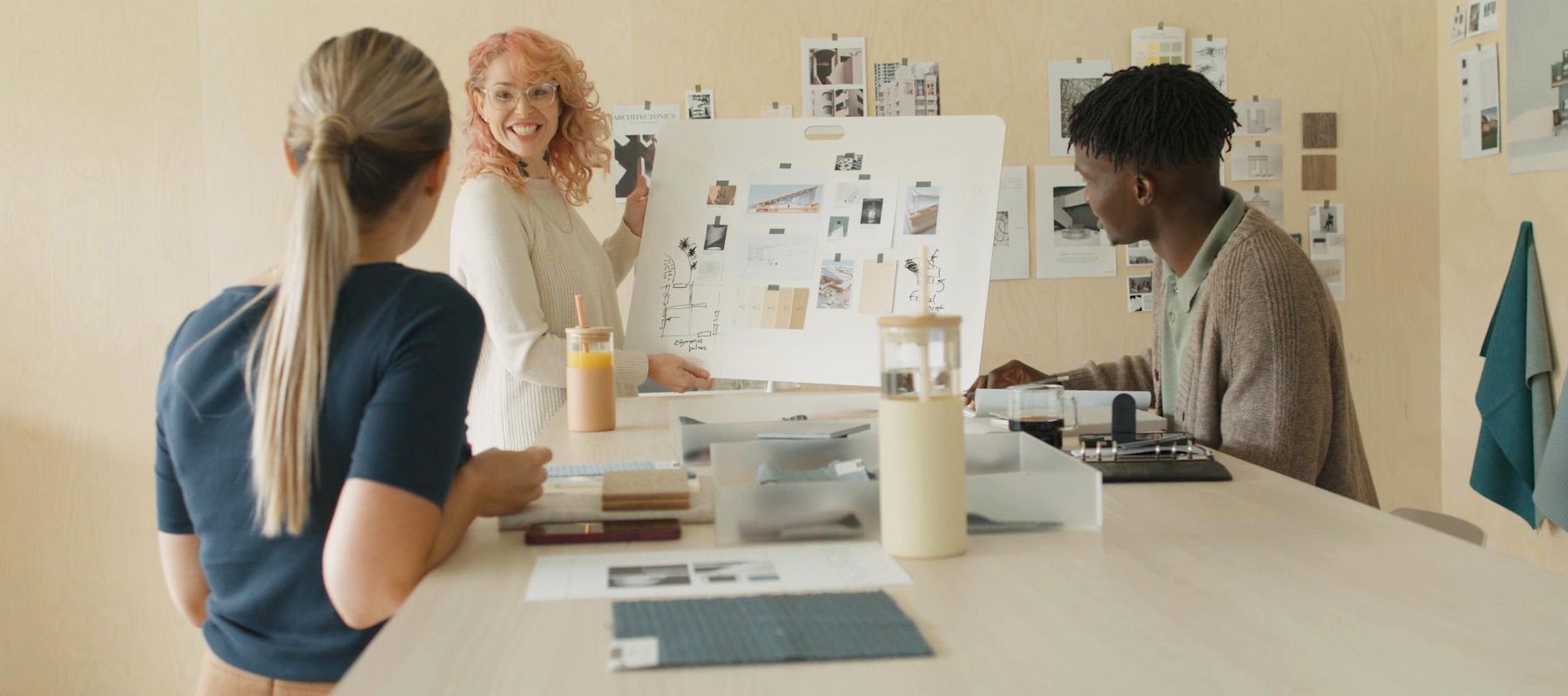 rencontre de trois personnes autour d'un plan d'aménagement de mobilier de bureau