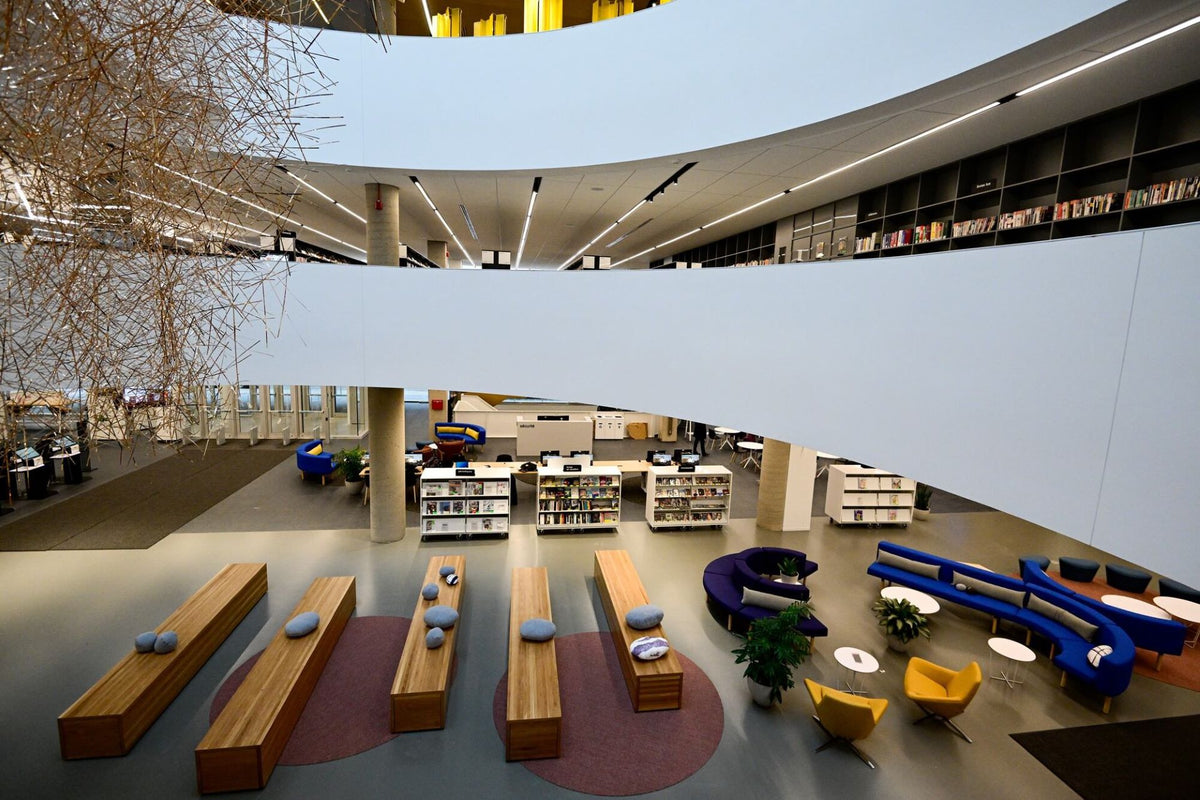 Salon de lecture moderne avec fauteuils design et mobilier de bureau contemporain - Aménagement bibliothèque