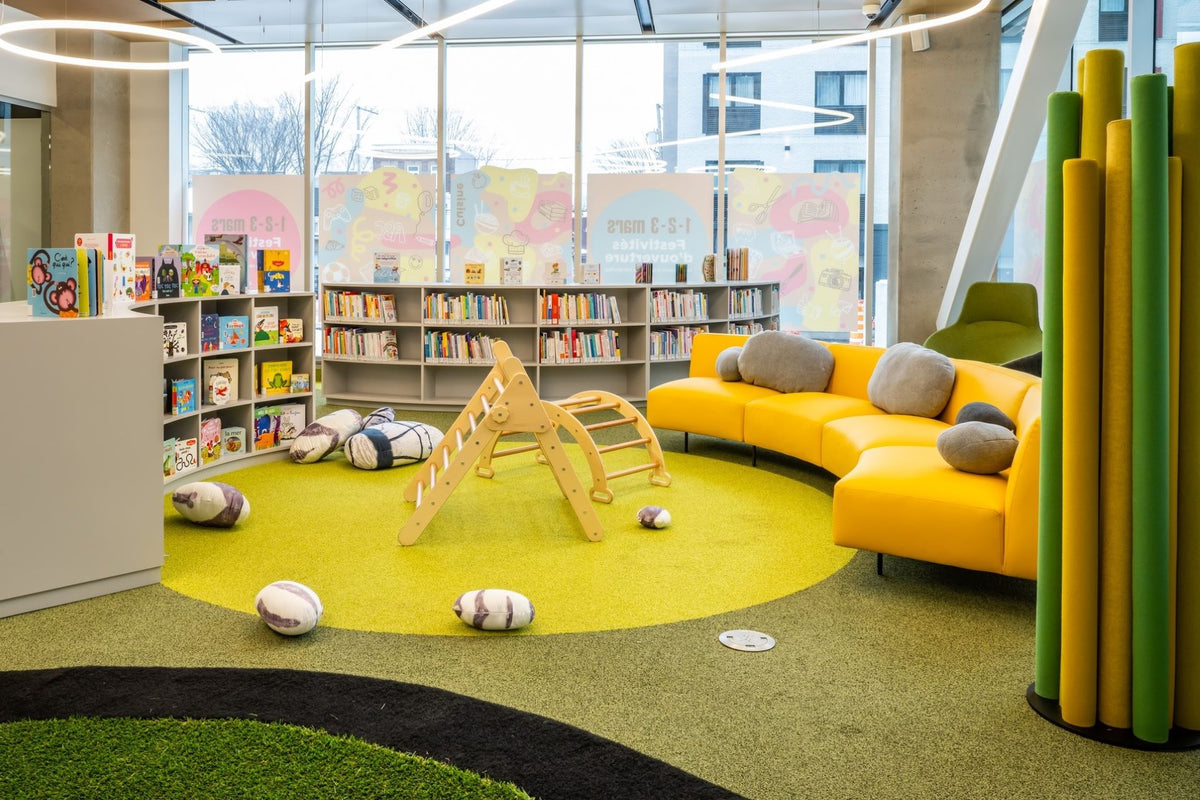 Espace enfants bibliothèque avec mobilier coloré - Canapé jaune, jeux éducatifs et aménagement ludique