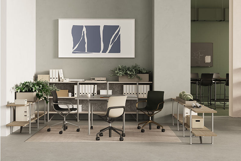 Espace de bureau collaboratif avec table partagée, chaises ergonomiques modernes, rangements ouverts et décoration végétale.