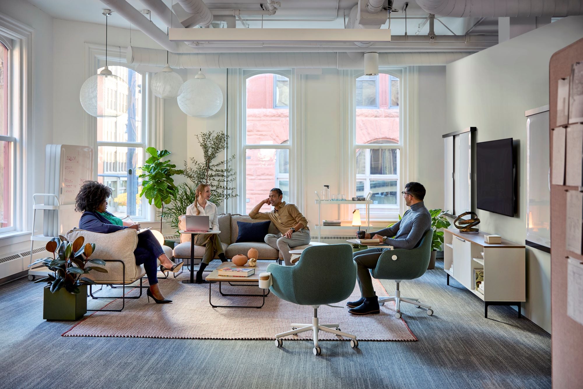 Espace de travail collaboratif moderne avec mobilier de bureau ergonomique - fauteuils pivotants, canapés et table basse professionnels