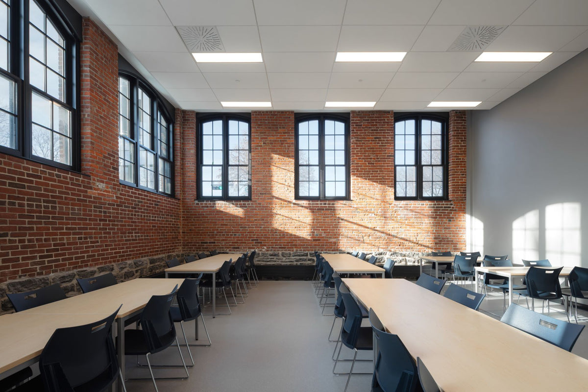 Salle à manger avec mobilier contemporain et murs de brique dans l’édifice patrimonial F.-X.-Drolet à Québec