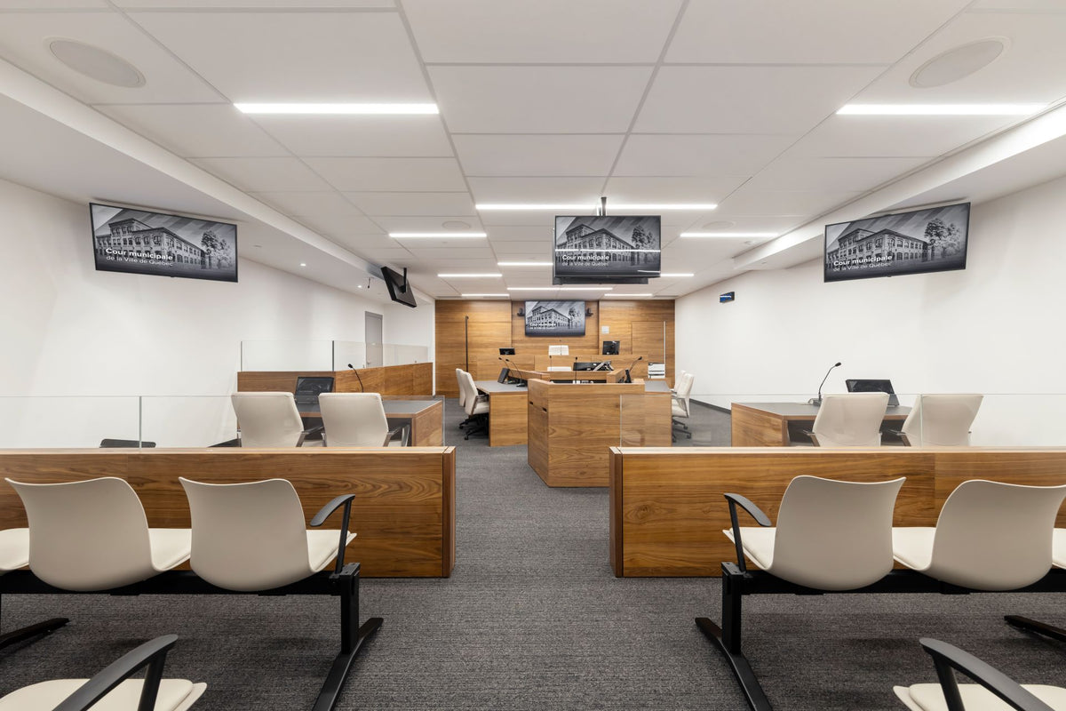 Salle de cour municipale avec mobilier moderne en bois et assises pour le public, dans l’édifice F.-X.-Drolet à Québec