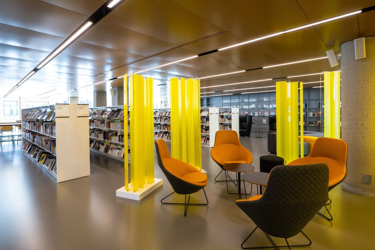 Espace lecture bibliothèque avec fauteuils lounge colorés - Mobilier de bureau moderne et aménagement contemporain