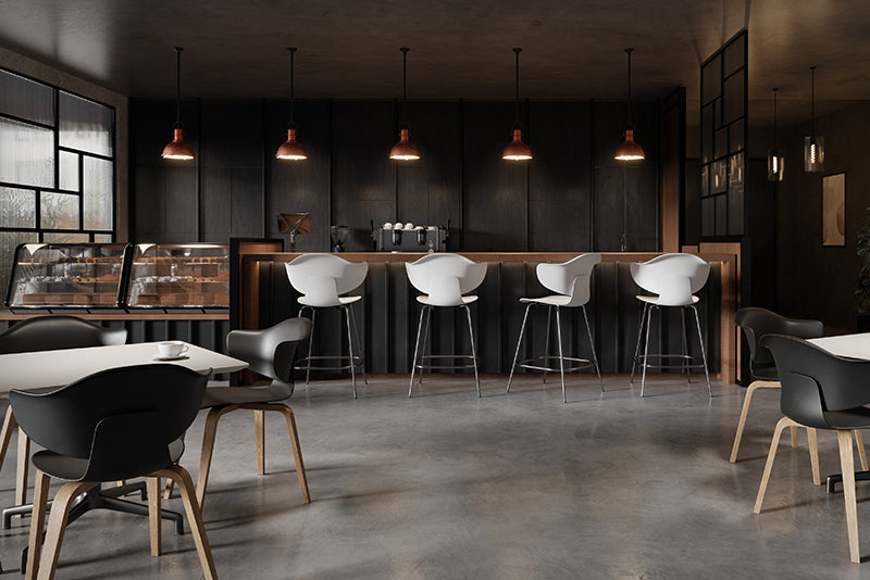 Espace café moderne avec comptoir en bois foncé, tabourets de bar blancs design et chaises noires ergonomiques, ambiance chaleureuse et éclairage suspendu idéal pour un environnement de travail ou de restauration contemporaine.