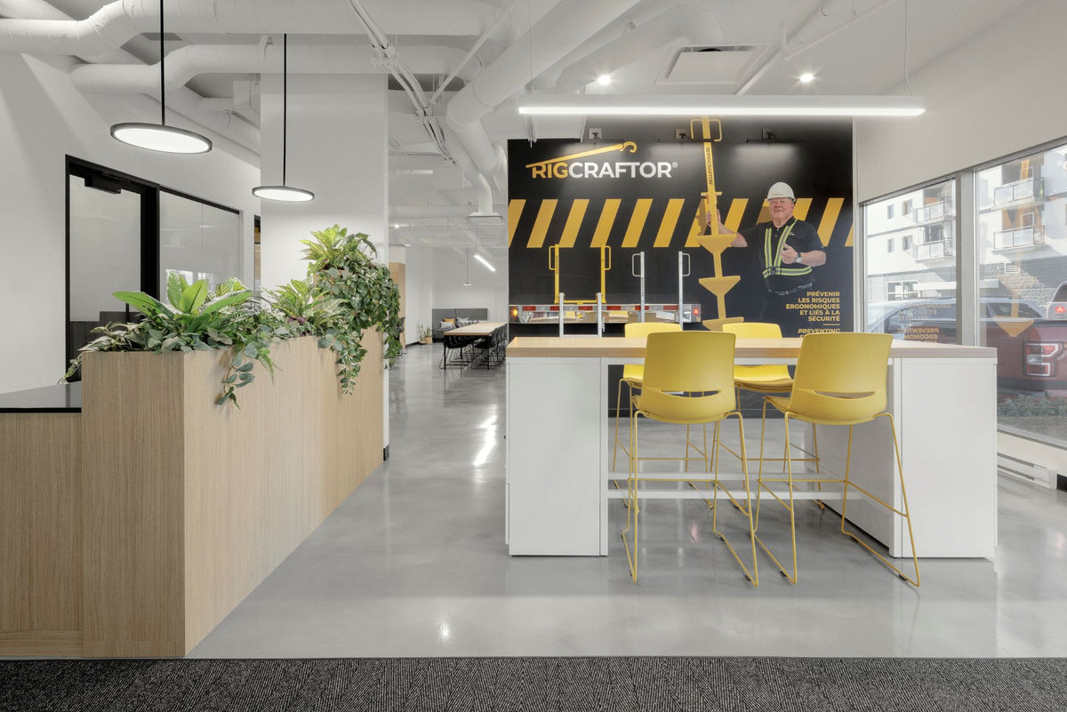 Espace de réception corporatif moderne avec îlot d'accueil, tabourets jaunes design et mur d'image de marque personnalisé aux couleurs de l'entreprise. Aménagement professionnel lumineux intégrant jardinières biophiliques, éclairage LED suspendu et mobilier contemporain pour créer une première impression mémorable.