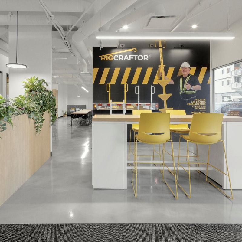Espace de réception corporatif moderne avec îlot d'accueil, tabourets jaunes design et mur d'image de marque personnalisé aux couleurs de l'entreprise. Aménagement professionnel lumineux intégrant jardinières biophiliques, éclairage LED suspendu et mobilier contemporain pour créer une première impression mémorable.