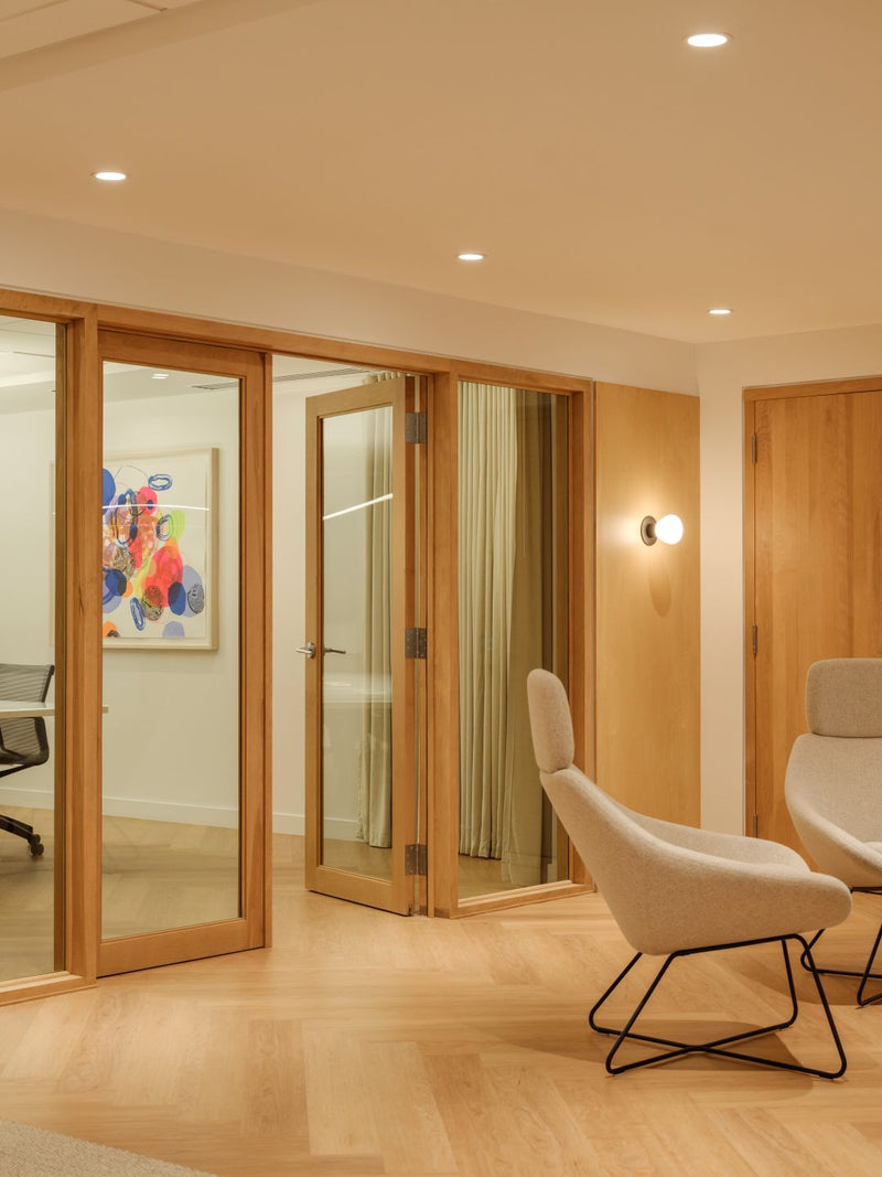 Bureau moderne avec cloisons vitrées bois et fauteuils ergonomiques blancs