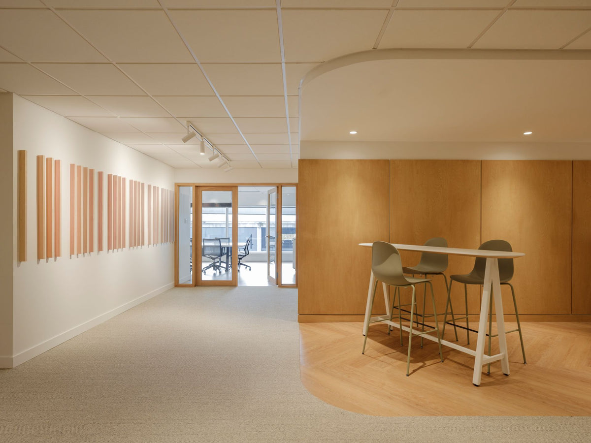 Bureau moderne avec table haute collaborative et décor mural biophilique