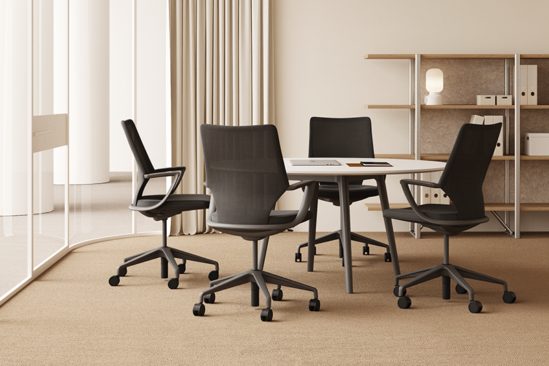 Salle de réunion minimaliste avec table carrée blanche, quatre chaises ergonomiques noires et étagères de rangement design.